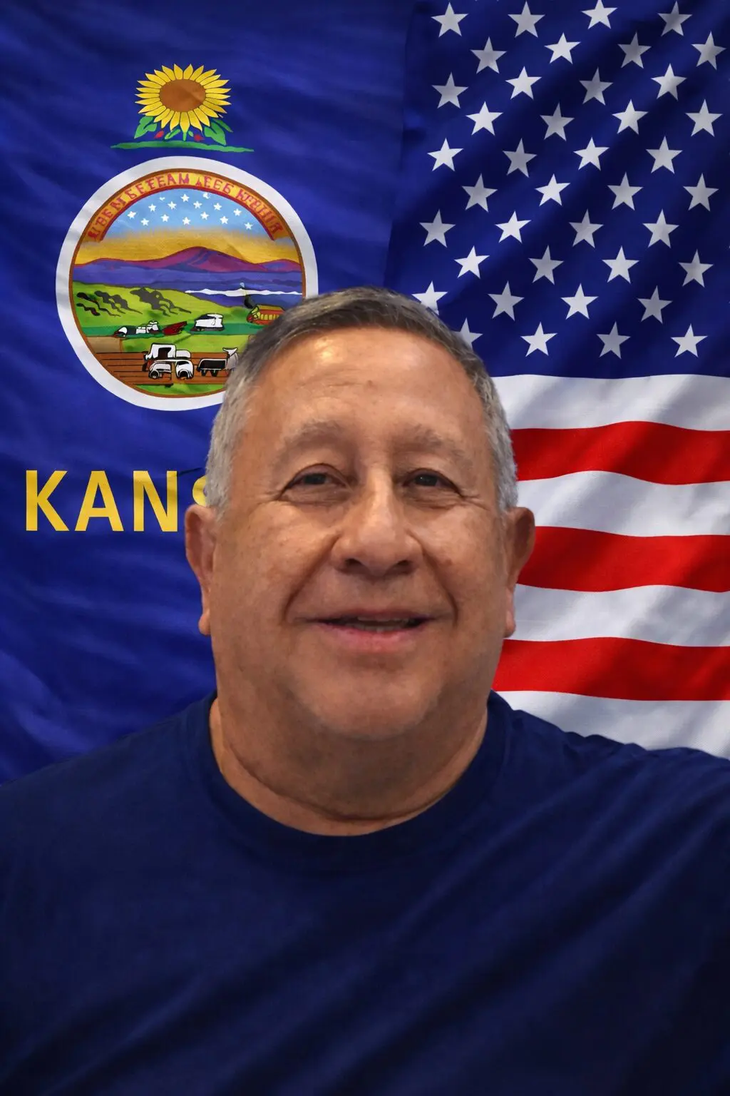Smiling man before Kansas and American flags