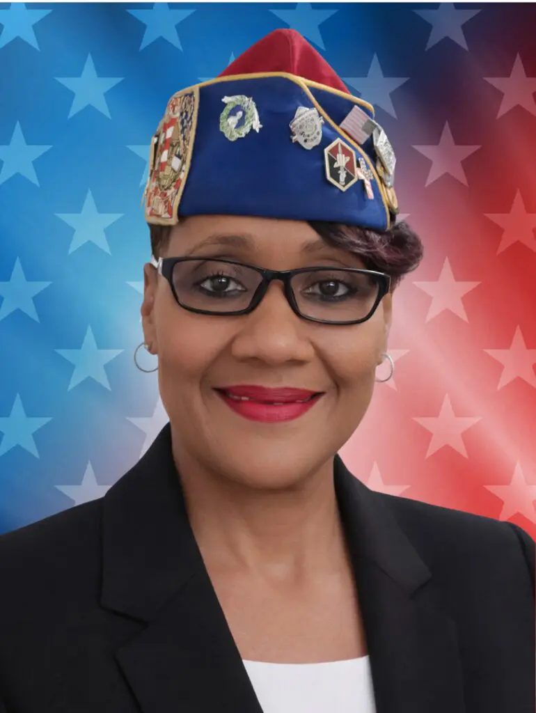 Smiling woman veteran in decorated cap, patriotic background